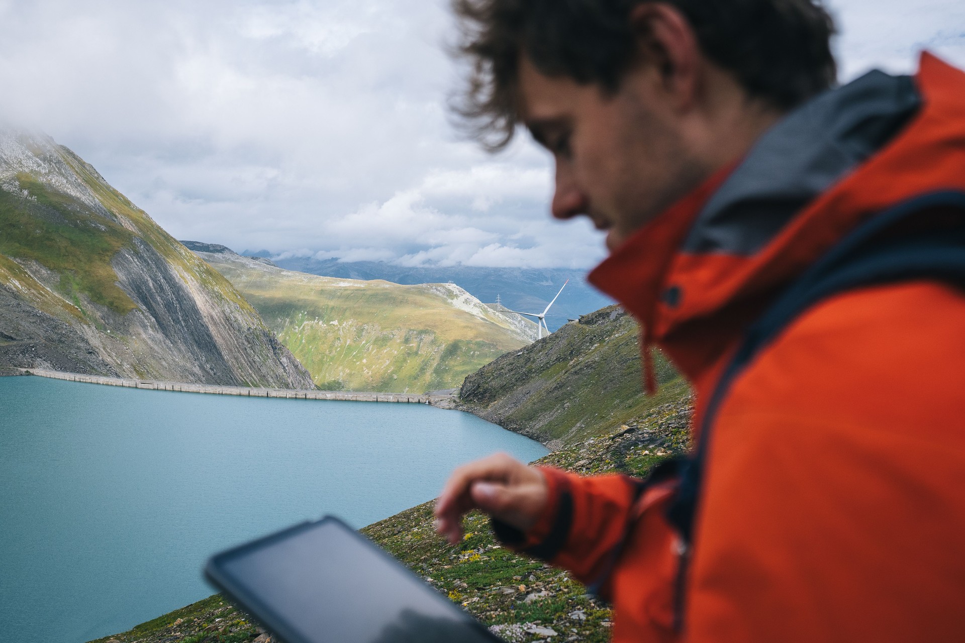 Backpacker uses digital tablet above alpine lake