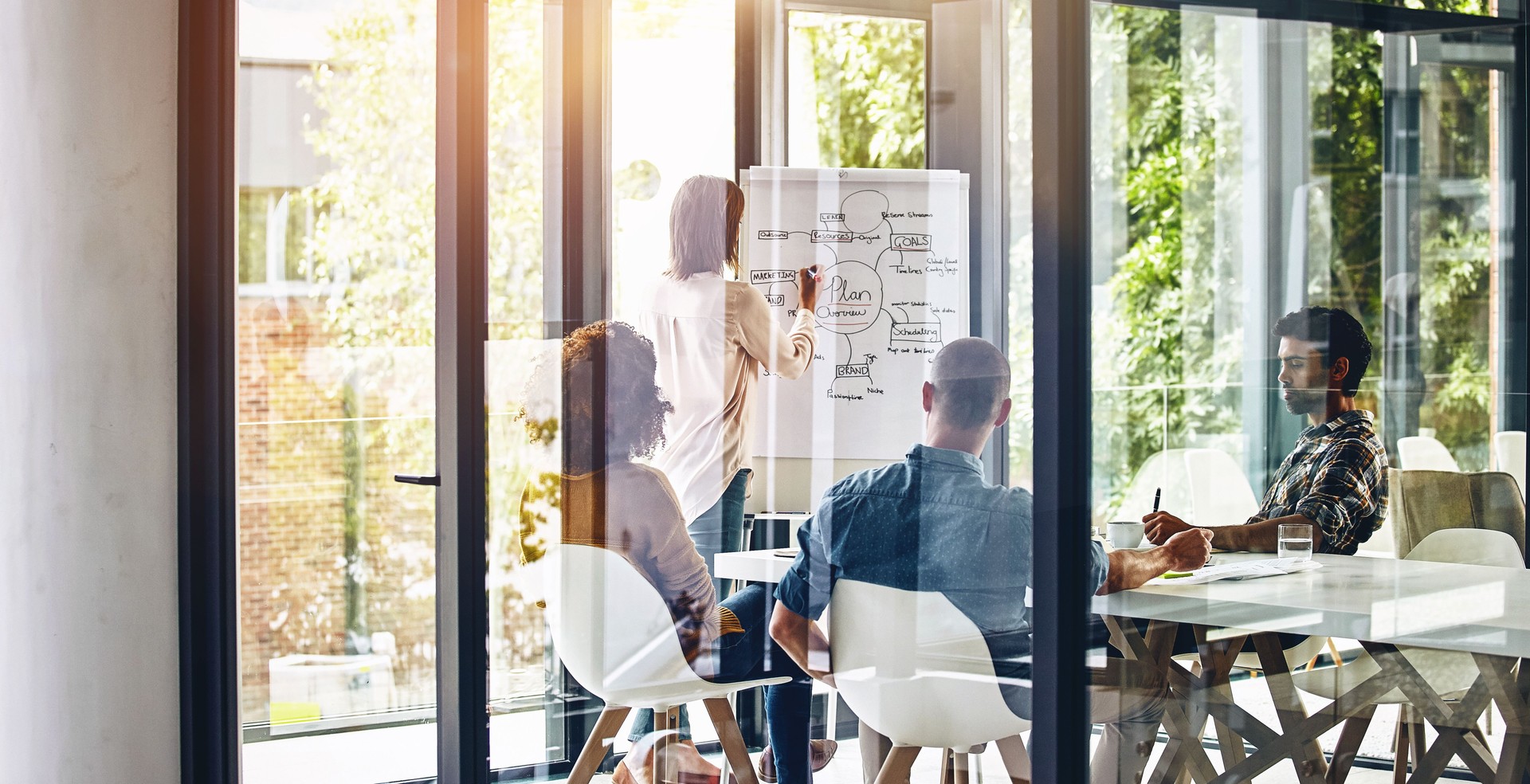 Meeting, presentation and whiteboard with business woman speaking to staff in boardroom of office. Coaching, seminar and training with employee talking to team in workplace for development or growth