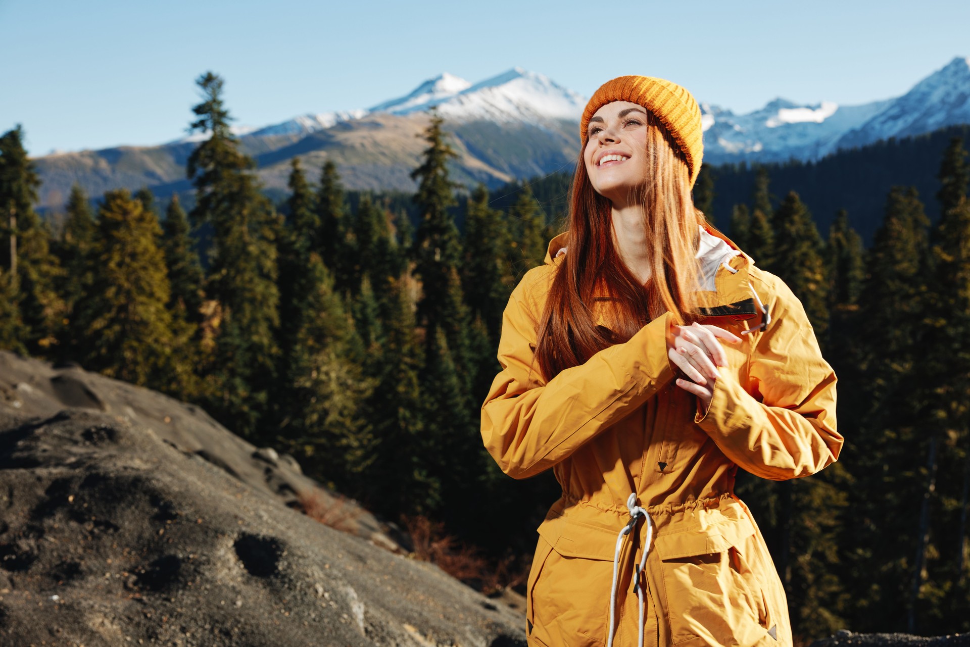 Woman smile with teeth happiness and laughter tourist in yellow raincoat travel in the fall and hiking in the mountains in the sunset sunshine freedom